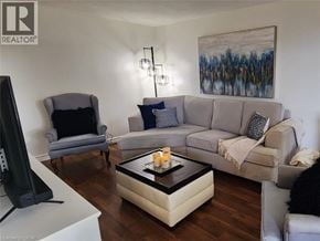 Kitchener condo for rent - A living room with a grey couch, a black chair, and a coffee table.