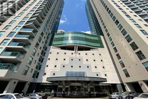 Toronto (Waterfront Communities) condo for rent - A tall building with a glass facade and a sign that reads "The New World Realty Inc." is seen in the foreground with cars parked in front.