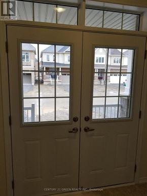 Thorold (Hurricane/Merrittville) apartment for rent - A white double door with a glass window showing a view of a residential area.