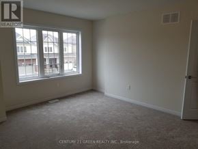 Thorold (Hurricane/Merrittville) apartment for rent - A room with a carpet floor and a window showing a view of buildings outside.