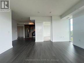 Toronto (Humber Heights) condo for rent - A spacious room with wood flooring and white walls, with a doorway leading to another room.