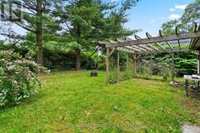 Niagara-On-The-Lake (Town) apartment for rent - A garden with a wooden pergola and a bench.