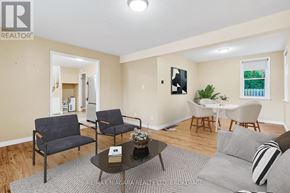 Niagara-On-The-Lake (Town) apartment for rent - A living room with a grey couch, a coffee table, and a dining table with chairs.