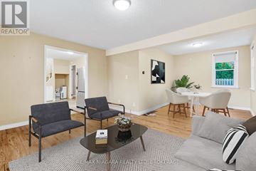 Niagara-On-The-Lake (Town) apartment for rent - A living room with a grey couch, a coffee table, and a dining table with chairs.