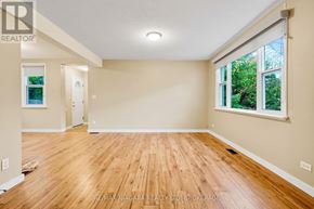 Niagara-On-The-Lake (Town) apartment for rent - A spacious room with wooden flooring and a window showing greenery outside.