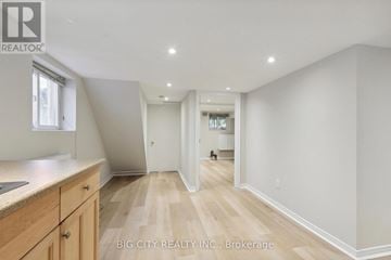 Toronto (Lawrence Park North) apartment for rent - A spacious room with wooden flooring and white walls, furnished with a kitchen area.