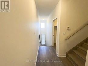 Markham (Cornell) townhouse for rent - A hallway with a staircase and a door at the end.