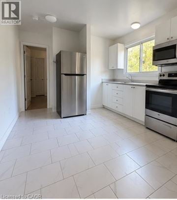 Kitchener apartment for rent - A white kitchen with a refrigerator and a microwave.