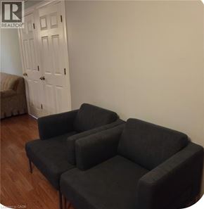 Hamilton apartment for rent - A black sectional sofa in a room with a white door.