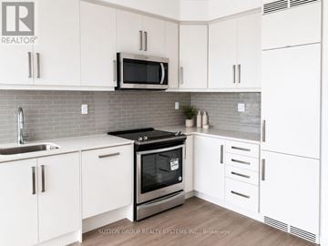 Toronto (Willowdale West) condo for rent - A modern kitchen with white cabinets and a stainless steel oven.