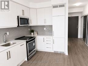 Toronto (Willowdale West) condo for rent - A kitchen with white cabinets and a black stove top oven.