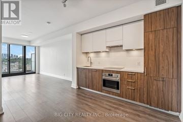 Toronto (Thorncliffe Park) condo for rent - A modern kitchen with wooden cabinets and a stainless steel oven.