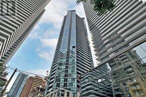 Toronto (Church-Yonge Corridor) condo for rent - A tall building with a striped facade stands in the middle of a cityscape.