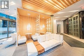 Toronto (Church-Yonge Corridor) condo for rent - A modern living room with a white sofa and wooden ceiling.