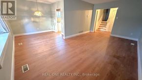 Toronto (Don Valley Village) apartment for rent - A room with wooden flooring and a Real One Realty Inc. logo on the wall.