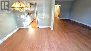 Toronto (Don Valley Village) apartment for rent - A room with wooden flooring and a Realty sign on the wall.