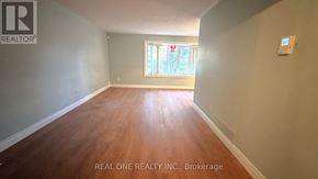 Toronto (Don Valley Village) apartment for rent - A room with wooden flooring and a window with a view of greenery outside.