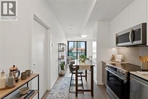 Kitchener condo for rent - A living room with a grey couch, a wooden chair, and a coffee table.