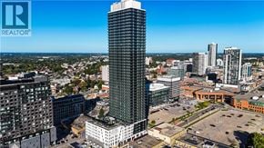 Kitchener condo for rent - A cityscape with a tall building in the foreground and a REALTOR® logo in the corner.