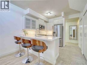 Vancouver apartment for rent - A modern kitchen with a bar stool and a refrigerator.