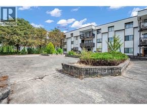 Maple Ridge apartment for rent - A large, empty parking lot in front of a multi-story residential building.