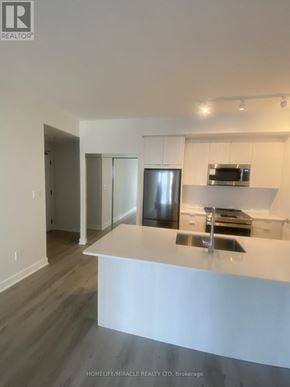 Mississauga (City Centre) condo for rent - A modern kitchen with a white countertop and stainless steel appliances.