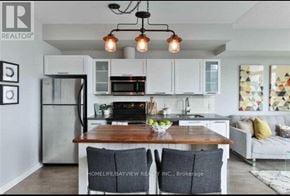 Toronto (Waterfront Communities) condo for rent - A modern kitchen with a wooden island and white cabinets.