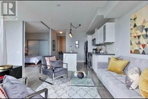 Toronto (Waterfront Communities) condo for rent - A modern living room with a grey couch and a glass coffee table.