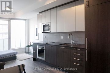 Toronto (Church-Yonge Corridor) condo for rent - A modern kitchen with dark wood cabinets and a stainless steel oven.