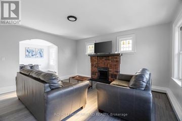 London South (South F) multi-family for rent - A living room with a grey couch and a fireplace.