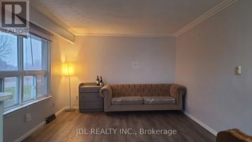 Bradford West Gwillimbury apartment for rent - A living room with a brown couch and a lamp.