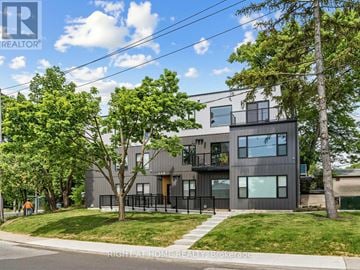 Toronto (High Park North) apartment for rent - A modern house with a balcony and a tree in front.