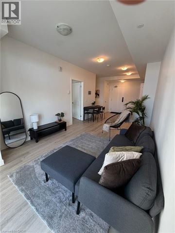 Stoney Creek condo for rent - A living room with a grey couch and a grey rug.