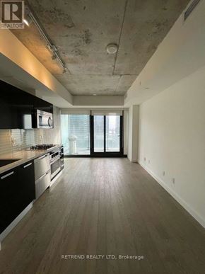 Toronto (Waterfront Communities) condo for rent - A spacious kitchen with wooden floors and a large window.
