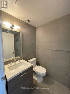 Toronto (Waterfront Communities) condo for rent - A bathroom with a toilet, sink, and mirror.