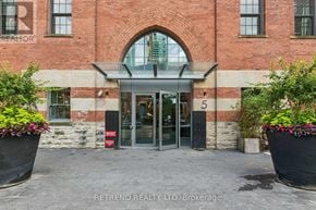 Toronto (Bay Street Corridor) condo for rent - The entrance to a building with a glass door and a stone pillar.