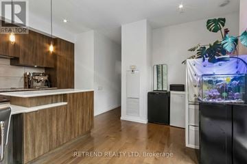 Toronto (Bay Street Corridor) condo for rent - A modern kitchen with wooden cabinets and a fish tank.