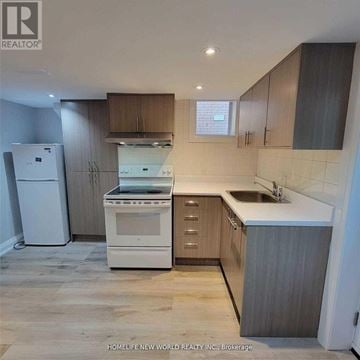 Toronto (Englemount-Lawrence) apartment for rent - A kitchen with a white fridge, white stove, and a white sink.