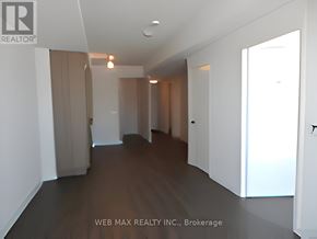 Toronto (Waterfront Communities) condo for rent - A long hallway with a light on the ceiling and a door on the right.