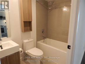 Toronto (Waterfront Communities) condo for rent - A white toilet sits next to a sink in a bathroom.