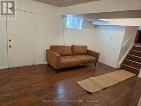Brampton (Madoc) apartment for rent - A brown couch sits in a white room with a tan rug on the floor.