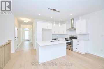 Niagara Falls (Chippawa) townhouse for rent - A spacious kitchen with white cabinets and a central island.
