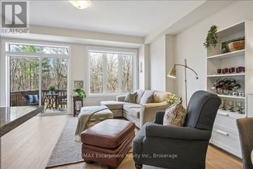 Burlington (Tyandaga) townhouse for rent - A living room with a couch, chair, and a table with a lamp.