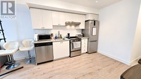 Toronto (Weston) condo for rent - A modern kitchen with stainless steel appliances and white cabinets.