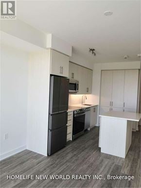 Richmond Hill (Langstaff) condo for rent - A kitchen with white cabinets and a black fridge.