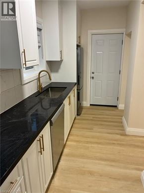 Hamilton apartment for rent - A kitchen with white cabinets and a black counter top.