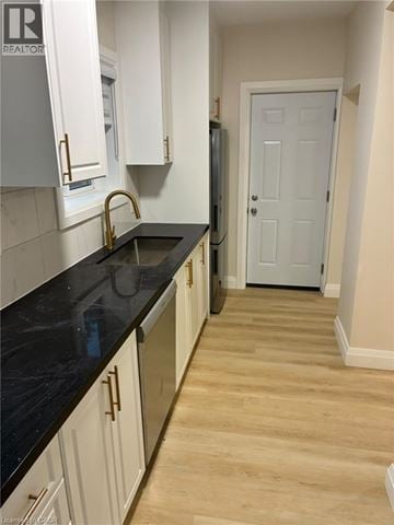 Hamilton apartment for rent - A kitchen with white cabinets and a black counter top.