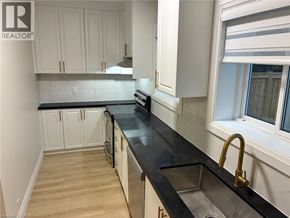 Hamilton apartment for rent - A kitchen with white cabinets and black countertops.