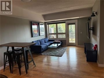 Sudbury apartment for rent - A living room with a blue couch and a wooden table.