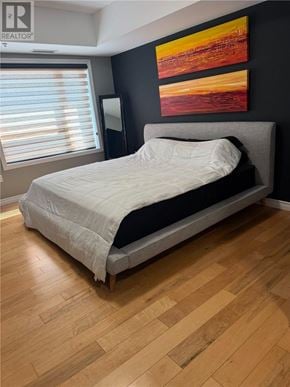 Sudbury apartment for rent - A bedroom with a bed, wooden flooring, and a painting on the wall.